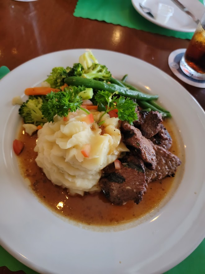 Steak tips with mashed potatos and steamed vegetables